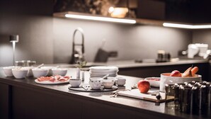 Una cocina moderna con salpicadero de mármol, electrodomésticos de acero inoxidable y una variedad de cuencos y platos sobre la encimera.