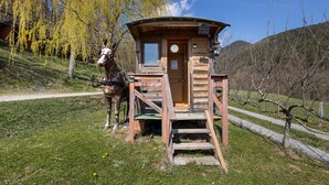 A wooden cabin with a staircase leading to the entrance, a horse standing nearby, and a path leading to the cabin. - Vacation Home "Els Mossos, El Reixac Casa Rural" with Mountain View, Shared Pool & Wi-Fi (Sant Joan de les Abadesses)
