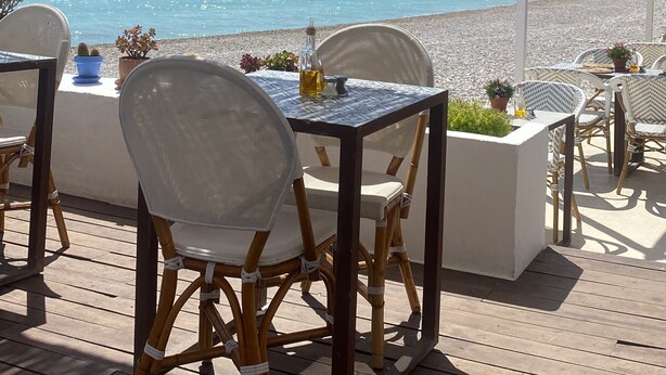 An outdoor dining area with tables and chairs, overlooking a beach and the sea. - Sungolfbeach El Girasol (orihuela)