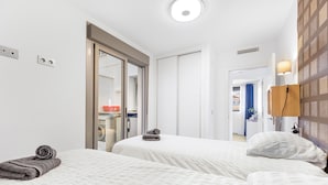 A hotel room with two beds, a wardrobe, a mirror, and a bathroom visible through an open door. - Sungolfbeach El Girasol (orihuela)