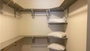 A compact storage closet with metal shelves and a padded bench. - Beautiful 2 Bedroom / 2 Bath Apartment in Houston by NRG Stadium (Houston)