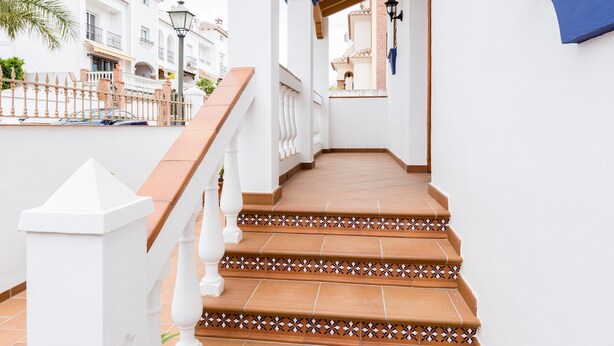 A staircase with white railings and terracotta tiles leading to a covered area with a lamp post. - Holiday Home 'Villa Zoe' with Sea View, Wi-Fi and Air Conditioning (Nerja)