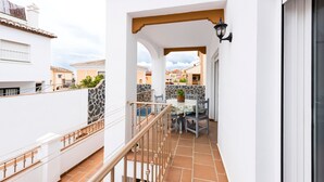 A balcony with a tiled floor, a railing, a table with chairs, and a potted plant. - Holiday Home 'Villa Zoe' with Sea View, Wi-Fi and Air Conditioning (Nerja)