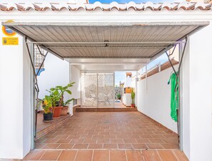 A covered patio area with tiled flooring, potted plants, and a decorative metal fence. - Holiday Home 'Villa Zoe' with Sea View, Wi-Fi and Air Conditioning (Nerja)
