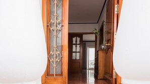 An arched doorway with a wooden frame and decorative glass panel, leading to a hallway with tiled flooring and a visible door at the end. - Holiday Home 'Villa Zoe' with Sea View, Wi-Fi and Air Conditioning (Nerja)