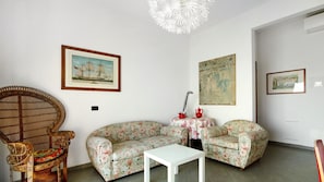 Una sala de estar con un sofá, una silla, una mesita y una lámpara decorativa.