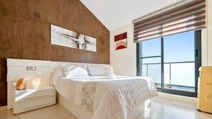 Una camera da letto moderna con un letto, un comodino e un'ampia finestra vista.