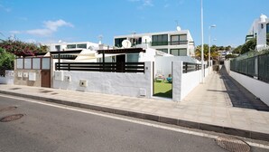 A modern residential building with a gated entrance, a paved sidewalk, and a clear sky. - Studio "Dannamar" near the beach with private terrace and Wi-Fi (Puerto del Carmen)