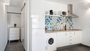 A compact kitchen with a washing machine, a microwave, and a coffee maker on the countertop. - Studio "Dannamar" near the beach with private terrace and Wi-Fi (Puerto del Carmen)