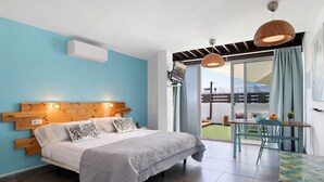 A bedroom with a bed, a wooden headboard, a ceiling fan, and a view of the outside. - Studio "Dannamar" near the beach with private terrace and Wi-Fi (Puerto del Carmen)