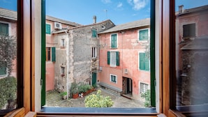 A courtyard with buildings, a wooden door, and a window frame.