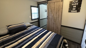 A bedroom with a bed, a sliding door, a window, and a motivational sign on the wall. - FS Rental #3 Annapolis, MO Black River (Annapolis)