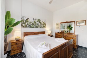 Habitació d'hotel amb un llit gran, nits de nit, un aparador, un mirall i un quadre penjat a la paret.