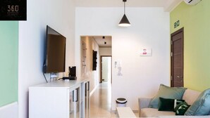 Een moderne woonkamer met een bank, een televisie en een glazen salontafel.