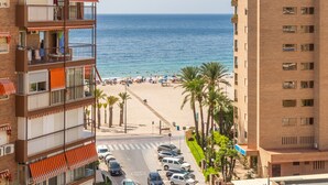 A multi-story building with balconies, a beach in the background, and parked cars in front. - Apartment 'Apartamento Paraíso Florida' with Sea View, Wi-Fi and Air Conditioning (Benidorm)