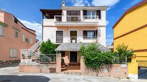 A two-story building with a balcony, a staircase, and a gate labeled 'VIA MAZZINI'. - Holiday Apartment "Corbezzolo" with Balcony & Shared Terrace (Bari sardo)