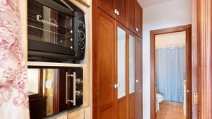 Una cocina con armarios de madera, un microondas y una estufa.