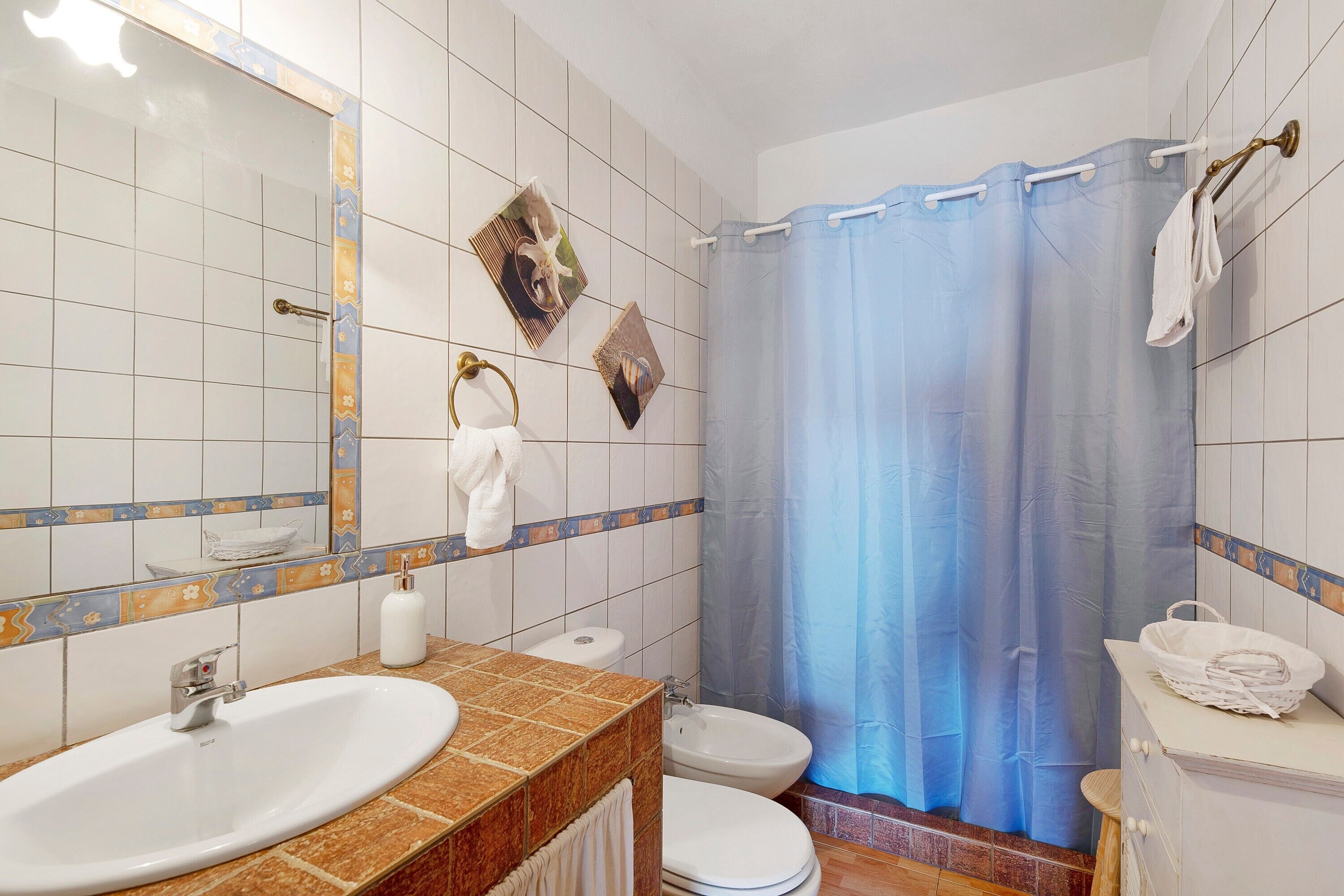 A bathroom with a sink, toilet, and shower curtain.