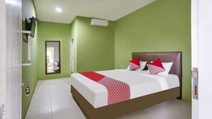 A hotel room with a bed, green walls, and a white tiled floor. - OYO Life 91027 Note Hotel Syariah (Prabumulih)