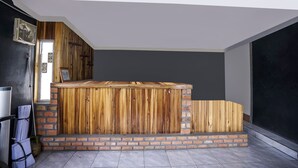 A room with a wooden bench, brick steps, and a door leading to another area. - OYO Life 91027 Note Hotel Syariah (Prabumulih)