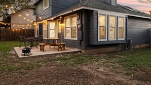 A house with a covered patio, a barbecue grill, and string lights. - Modern Comfort: WiFi, 3BR, King, Patio (Round Rock)