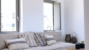 Un saló modern i minimalista amb un sofà integrat, una taula de centre de fusta i un petó teixit.