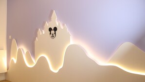 Un muro con la silhouette di Topolino e un design luminoso ondulato.