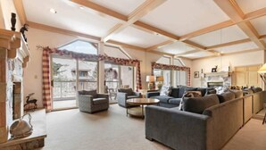 A spacious living room with a fireplace, large windows, and a cozy seating area. - Saint James Place PL4 (Avon)