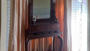 A room with a wooden dresser, a mirror, and curtains. - Manikkal Outhouse Cottage Wayanad (Mananthavady)