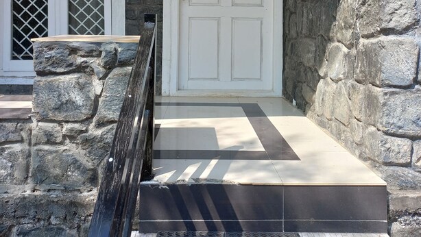 A stone facade with a white door and a red trim. - Manikkal Outhouse Cottage Wayanad (Mananthavady)