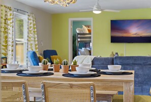 A dining area with a wooden table set for four, surrounded by chairs. - Tropical Beach Casita Oasis, Heated Pool, Golf (Clearwater)