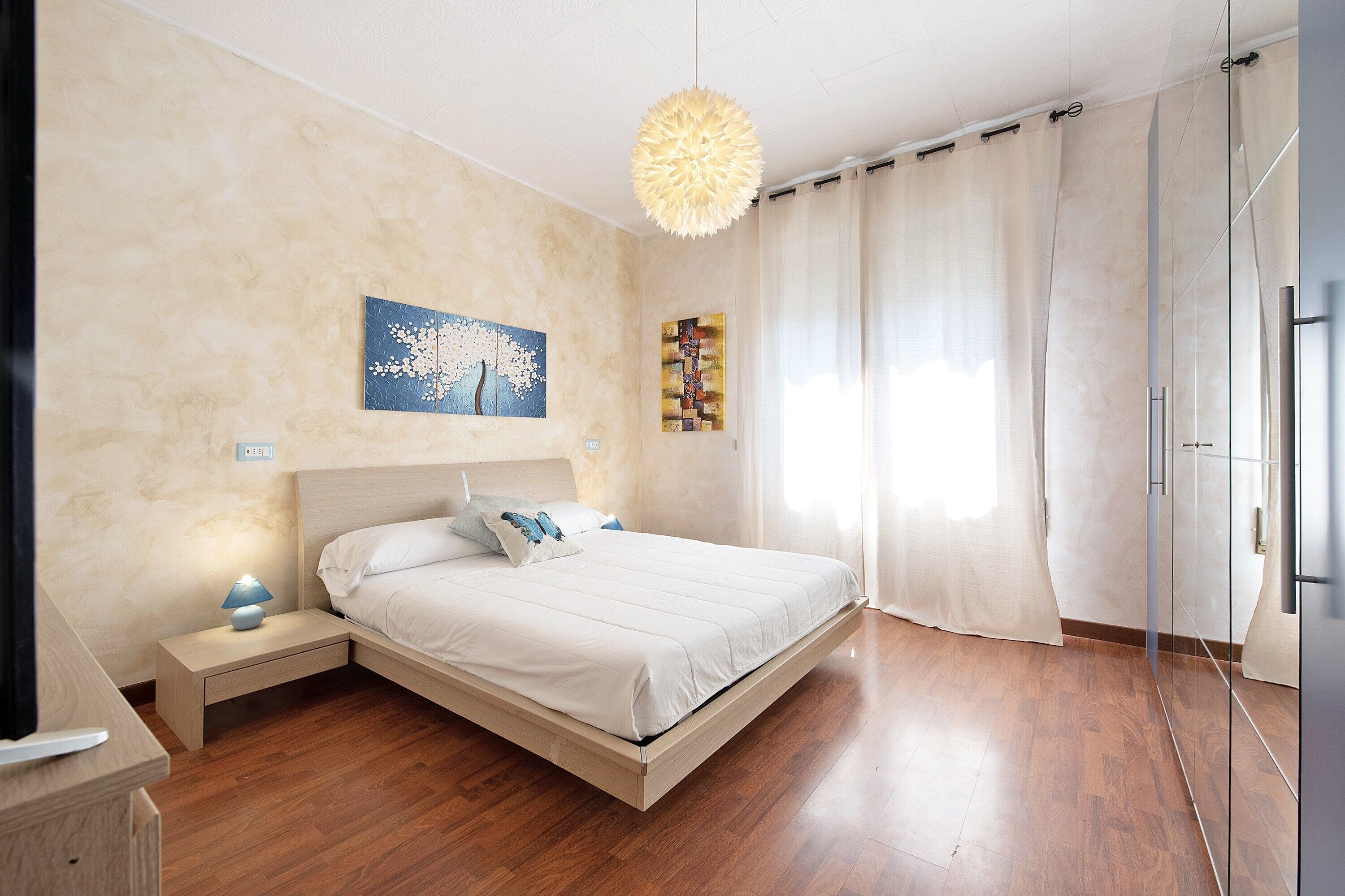 Una camera da letto con un letto, un comodino e un'opera d'arte a parete.