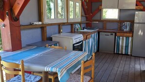 A compact cabin with a dining area, kitchenette, and a small bathroom.