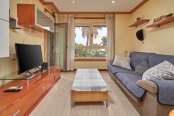 A living room with a TV, sofa, and a table.
