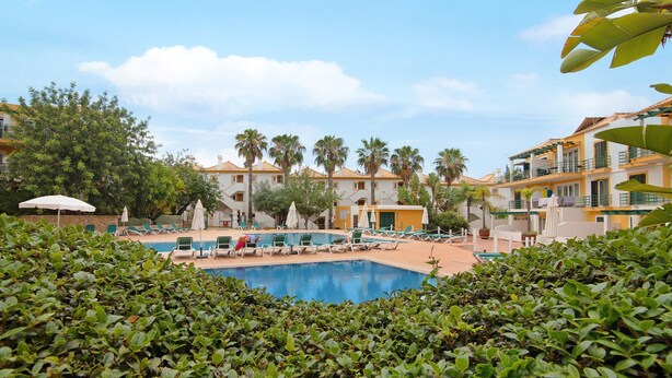 A hotel with a swimming pool, palm trees, and lounge chairs. - Apartment 'Tavirasol' with Shared Pool, Wi-Fi and Air Conditioning (Tavira)