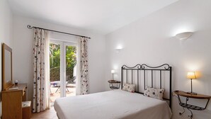 A bedroom with a bed, bedside tables, a desk, and a window with curtains. - Apartment 'Tavirasol' with Shared Pool, Wi-Fi and Air Conditioning (Tavira)