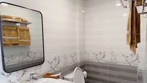 Un baño moderno con un lavabo blanco, inodoro y espejo.