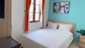 Un dormitorio con cama, ventana con cortinas, un cuadro en la pared y un escritorio.