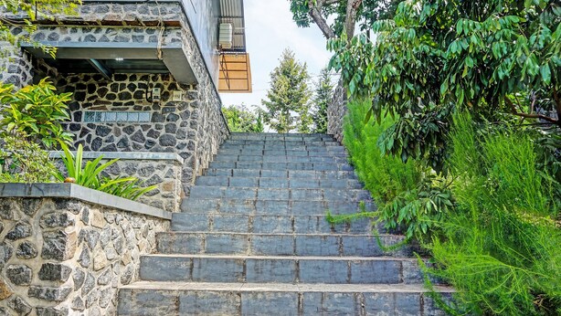 A set of stone steps leading up to a building with a stone facade and a small overhang.