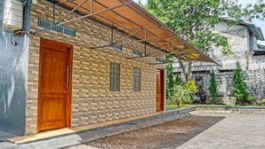 A building with a brick facade, two wooden doors, and a covered entrance area.