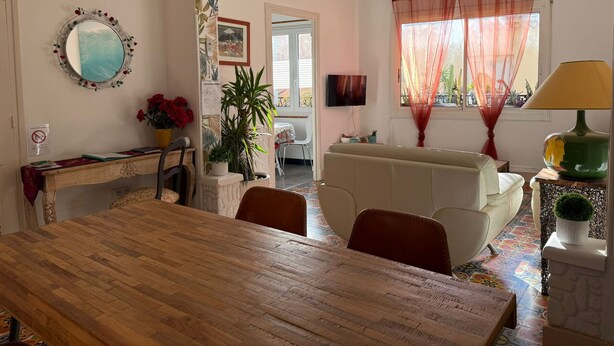 Un salon chaleureux avec une table à manger en bois, un canapé et un téléviseur.