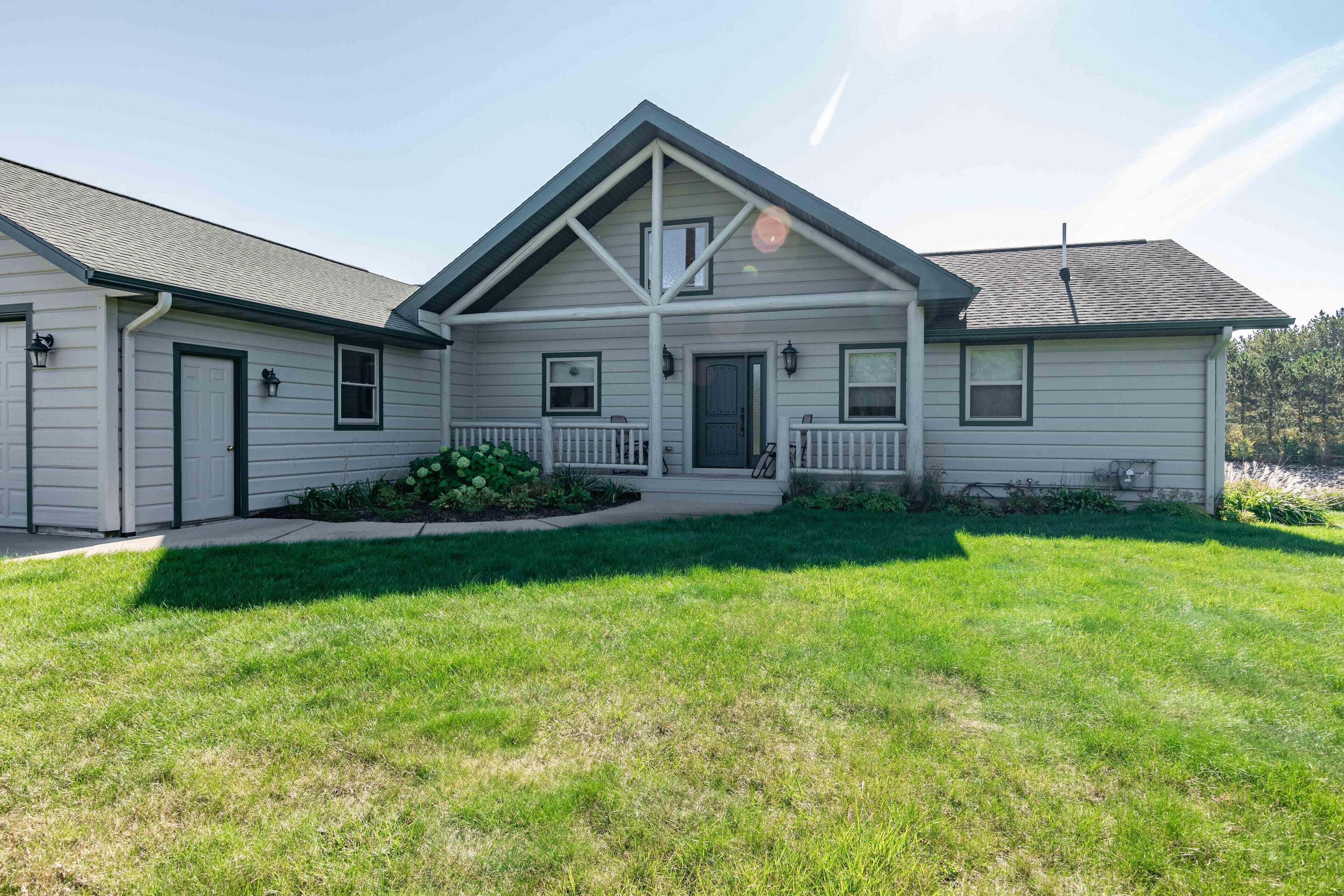 A two-story house with a front porch, a garage, and a well-maintained lawn.