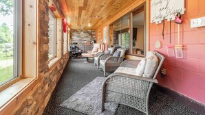 A cozy room with wicker furniture, a stone wall, and a sign reading "Sandy Toads and Salty Kisses". - LOVELY LAKEFRONT HOME ON THE EASTERN SIDE OF CASTLE ROCK LAKE (Friendship)