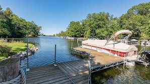 A dock with a boat named 'LOWE' docked at a calm lake surrounded by trees. - LOVELY LAKEFRONT HOME ON THE EASTERN SIDE OF CASTLE ROCK LAKE (Friendship)
