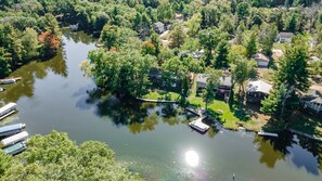 An aerial view of a residential area with houses, a lake, and boats.