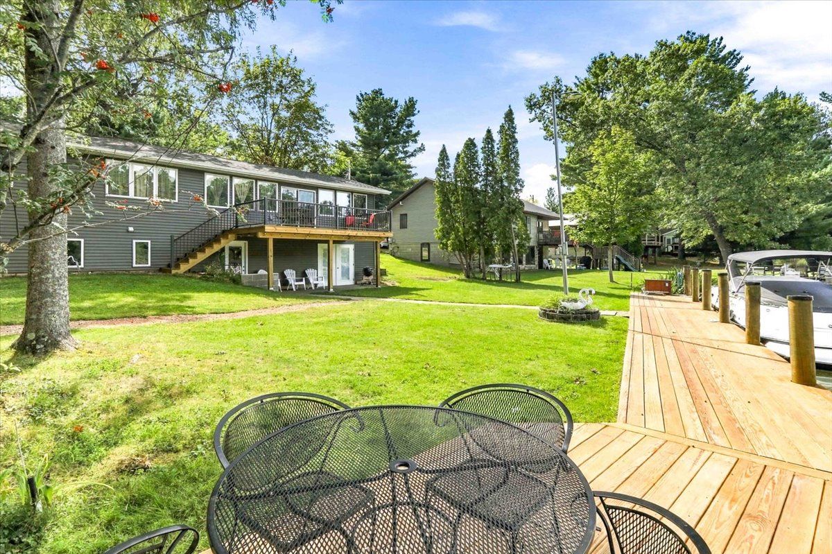 Een woonhuis met een terras, zitplaatsen buiten en een overdekt gedeelte.