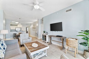 Un salon moderne avec un canapé, une table basse et un téléviseur fixé au mur.