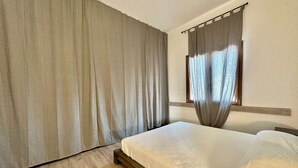 Ein Hotelzimmer mit einem Bett, Vorhängen und einem Fenster.