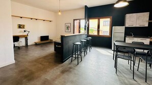 Eine moderne Küche mit schwarzem Arbeitsplatz, Barhocker und einem Essbereich mit schwarzen Stühlen.
