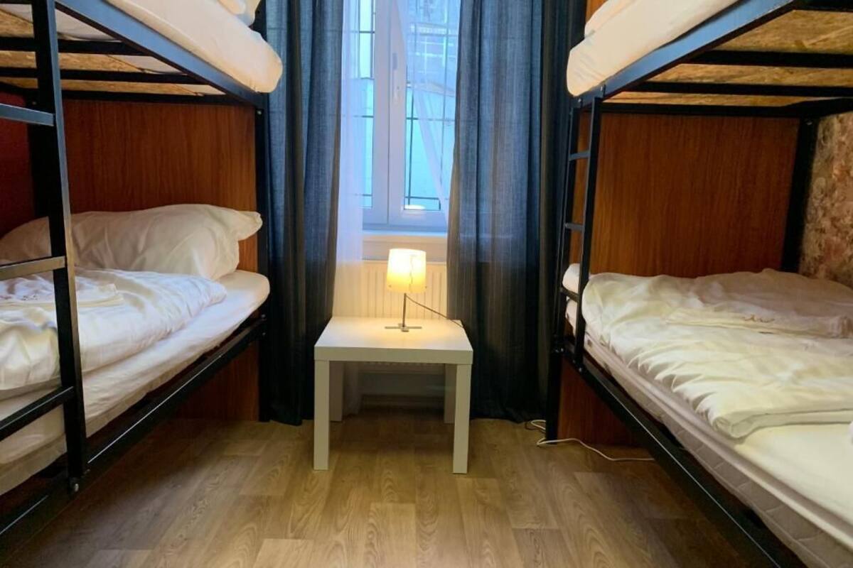 A bunk bed room with a small table and a lamp in the center.